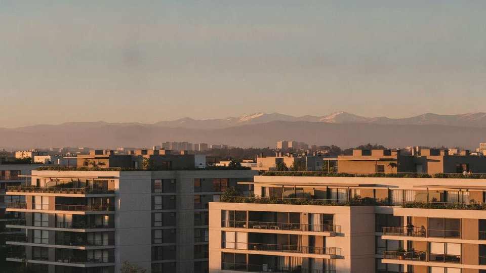Edificios de departamentos en comunas de Santiago al atardecer, vista editorial para inversión inmobiliaria